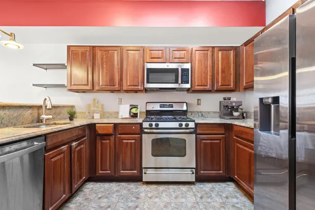 a kitchen with stainless steel appliances granite countertop a sink stove and microwave