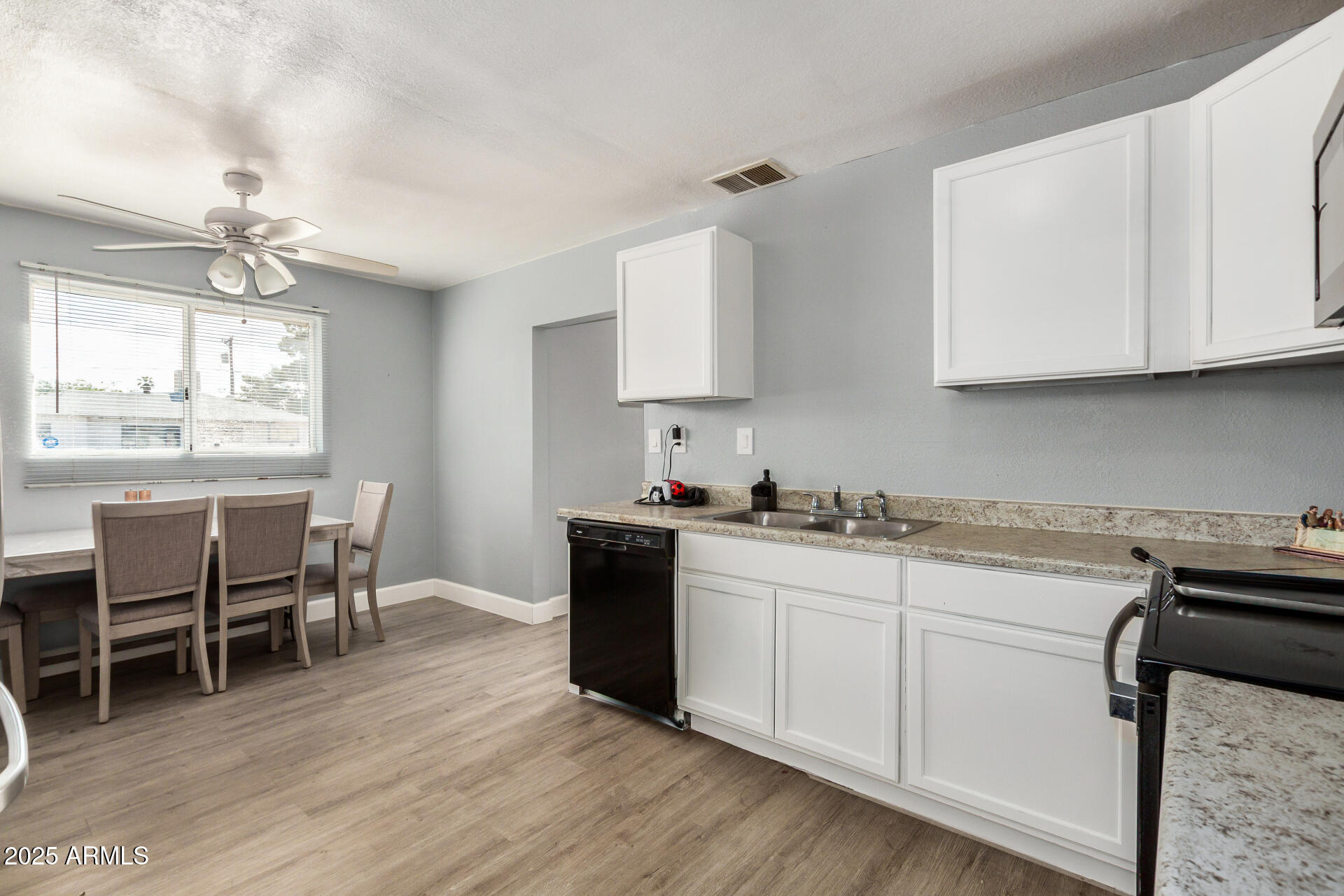 2726 West Ruth Avenue Phoenix, AZ 85051 - Photo 12 of 28 a kitchen with a sink cabinets and dining table chair