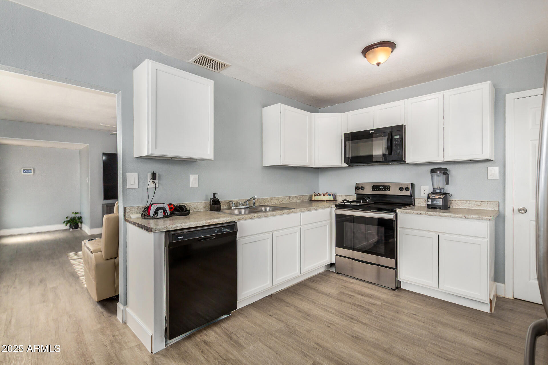 2726 West Ruth Avenue Phoenix, AZ 85051 - Photo 13 of 28 a kitchen with granite countertop a sink cabinets and stainless steel appliances