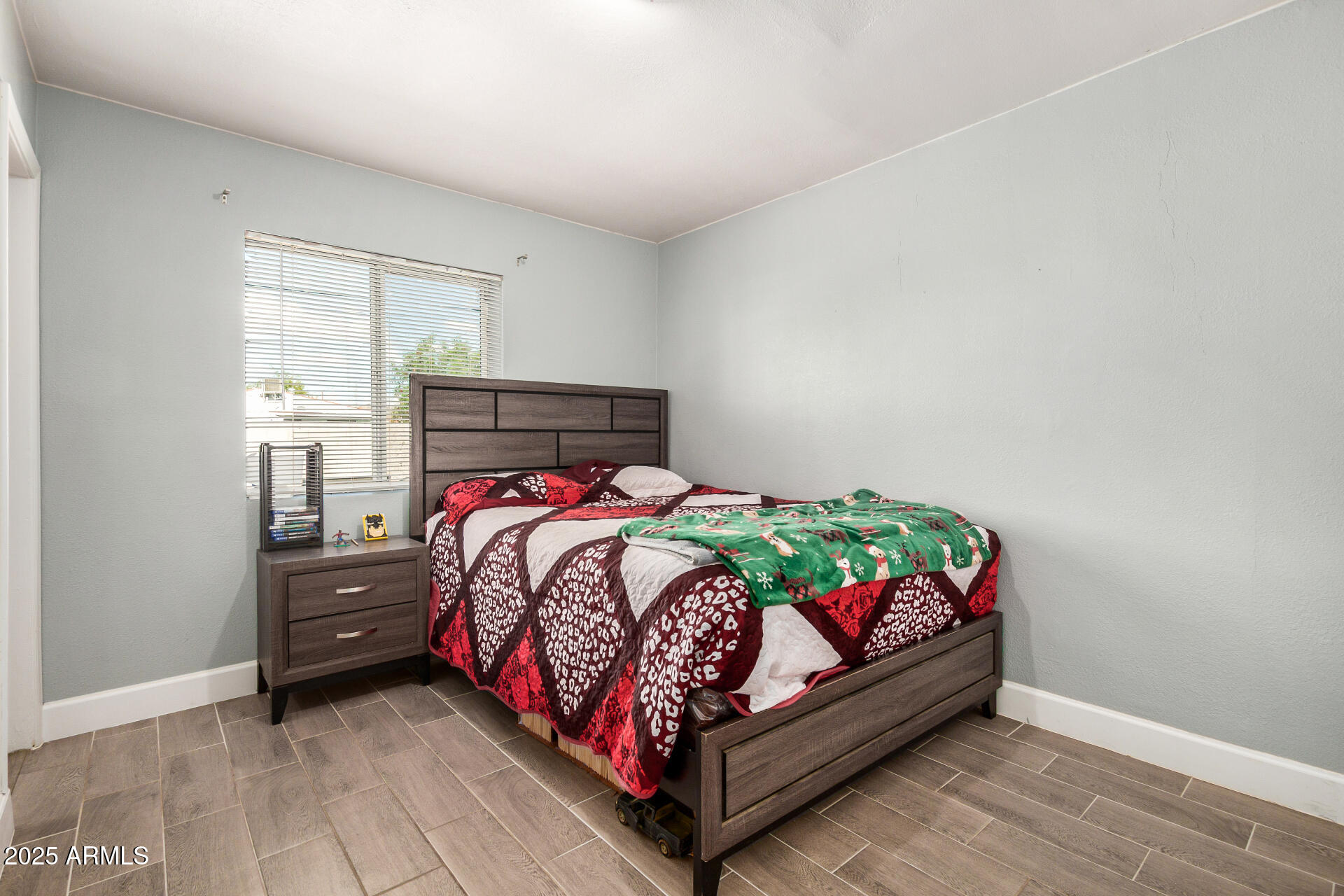 2726 West Ruth Avenue Phoenix, AZ 85051 - Photo 20 of 28 a bed sitting in a bedroom next to a window