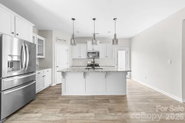a large kitchen with stainless steel appliances kitchen island granite countertop a sink and cabinets