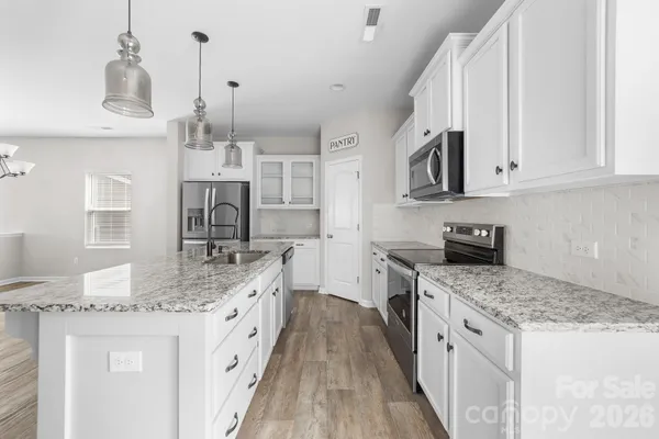 a kitchen with stainless steel appliances granite countertop a refrigerator and a sink