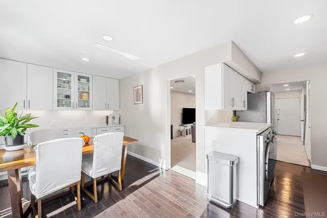 a living room with furniture a wooden floor and a kitchen view