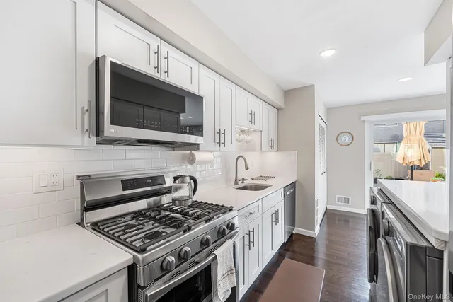 a kitchen with stainless steel appliances a stove a sink and a microwave