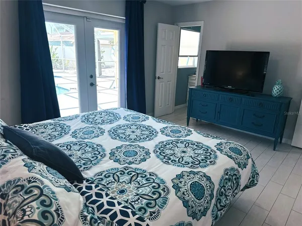 a bedroom with a bed and a flat screen tv