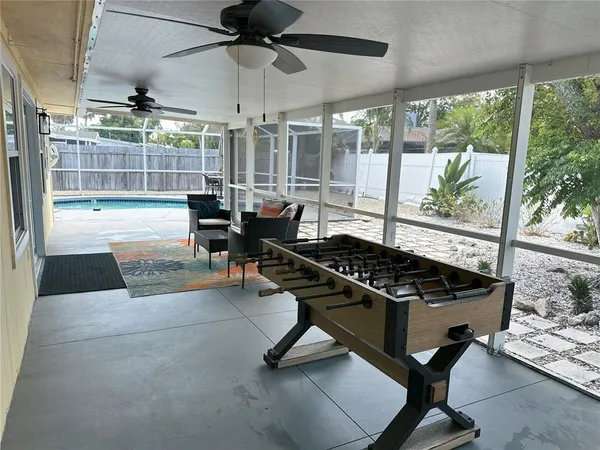 a living room with patio furniture and a floor to ceiling window