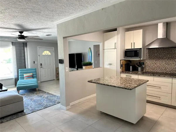 a kitchen with stainless steel appliances granite countertop a sink and a stove top oven with wooden floor