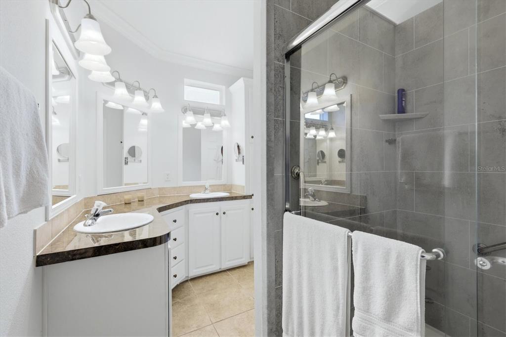 1 Meadow Circle Ellenton, FL 34222 - Photo 21 of 43 a bathroom with a granite countertop sink a large mirror and a shower