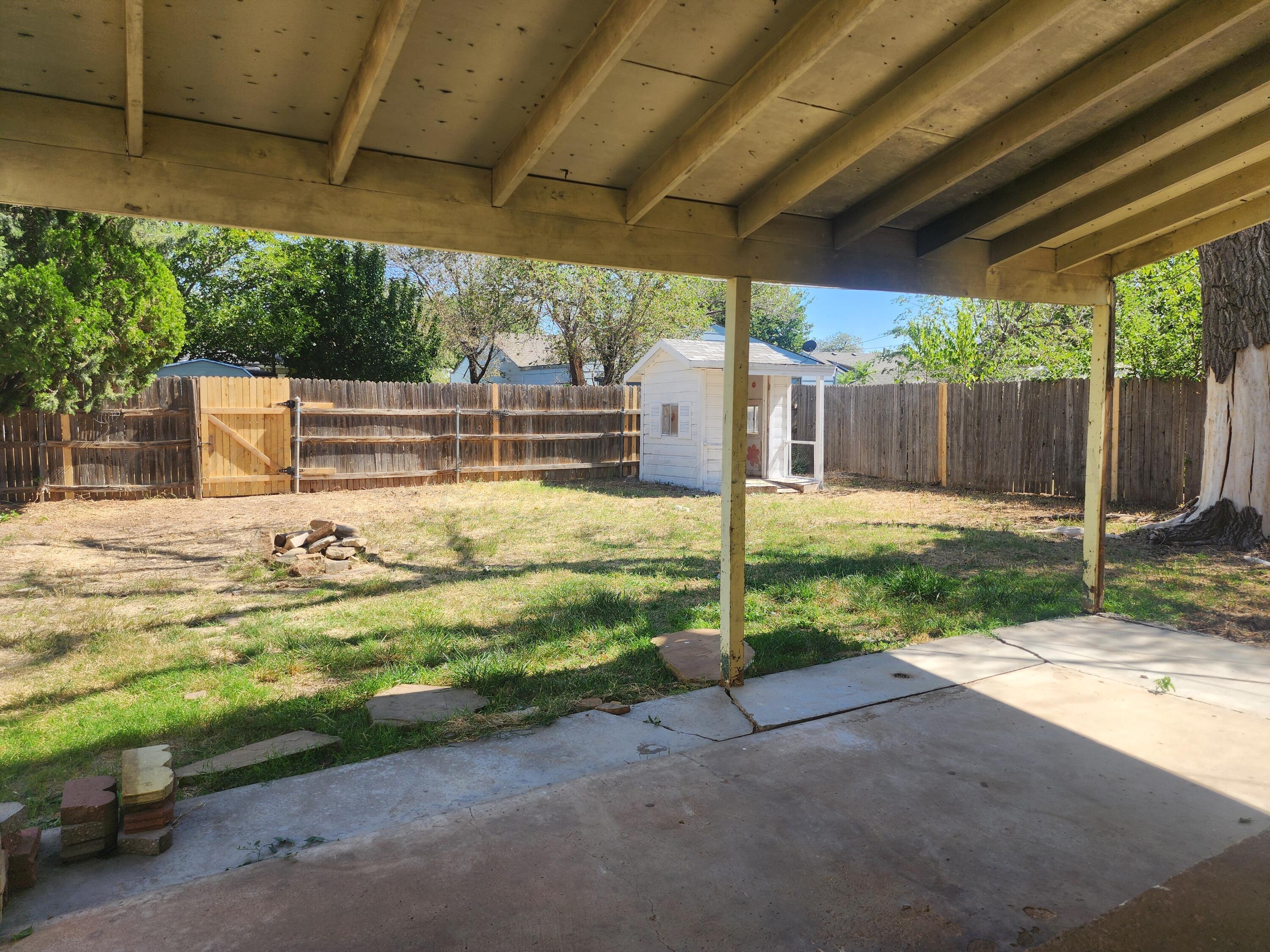 4003 Cline Road Amarillo, TX 79110 - Photo 13 of 17 a view of a backyard with table and chairs under an umbrella