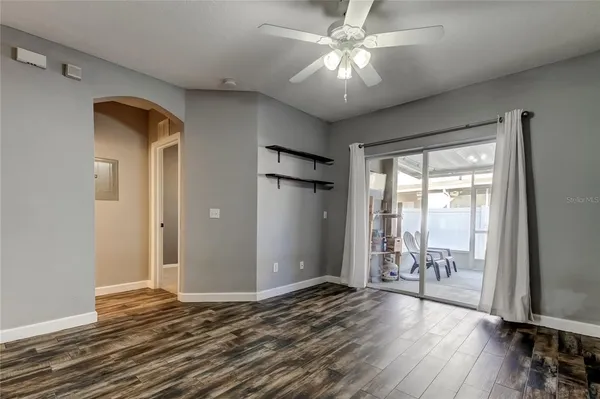 a view of a livingroom with wooden floor and a ceiling fan