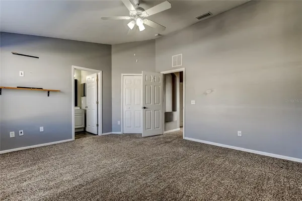 an empty room with fan and entrance