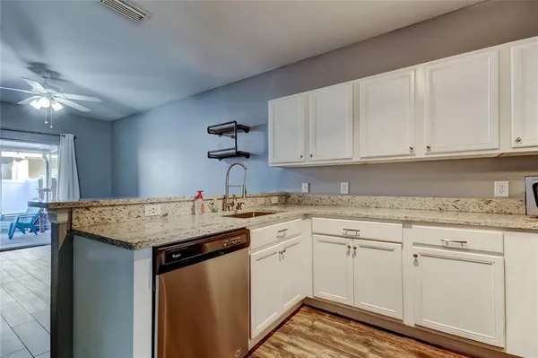a kitchen with granite countertop a sink stove and cabinets