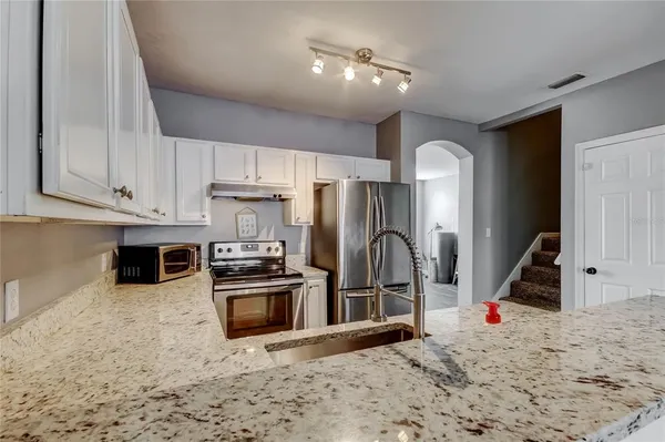 a kitchen with stainless steel appliances granite countertop a refrigerator and a stove