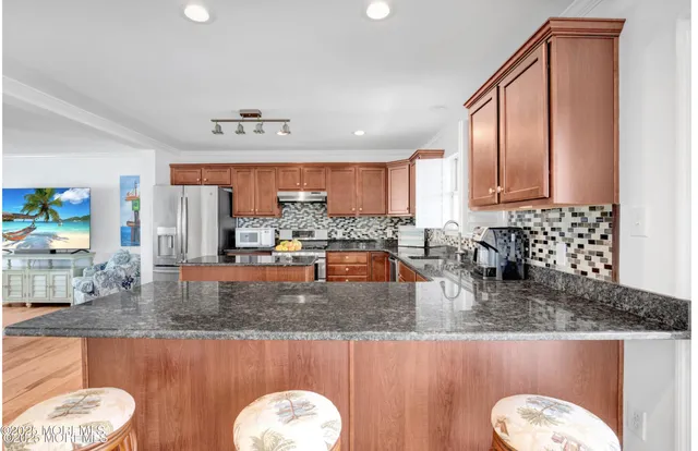 a kitchen with stainless steel appliances granite countertop a sink a stove counter space and cabinets