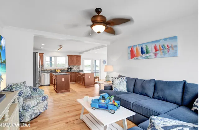 a living room with furniture kitchen view and a chandelier