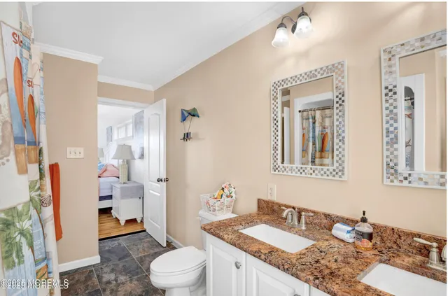 a bathroom with a granite countertop sink mirror vanity and toilet