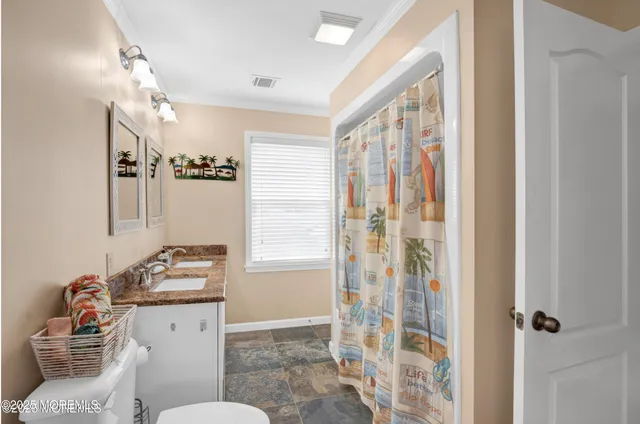 a bathroom with a granite countertop sink a mirror a vanity and next to a window