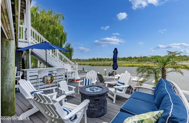 a view of a patio with couches chairs potted plants and city view
