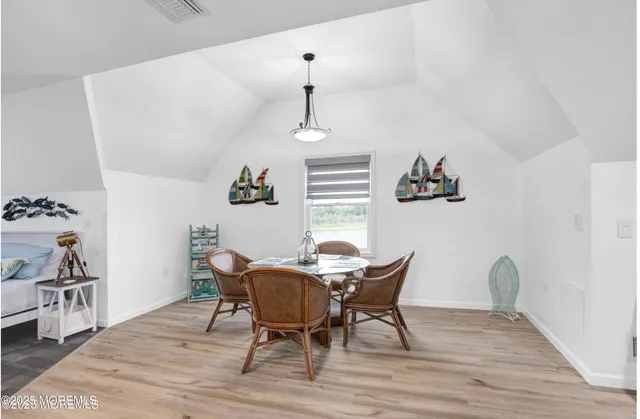 a dining room with furniture wooden floor a rug and a chandelier