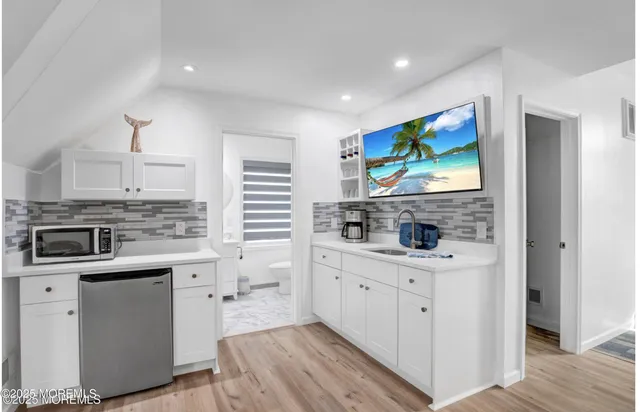 a kitchen with white cabinets sink and stainless steel appliances