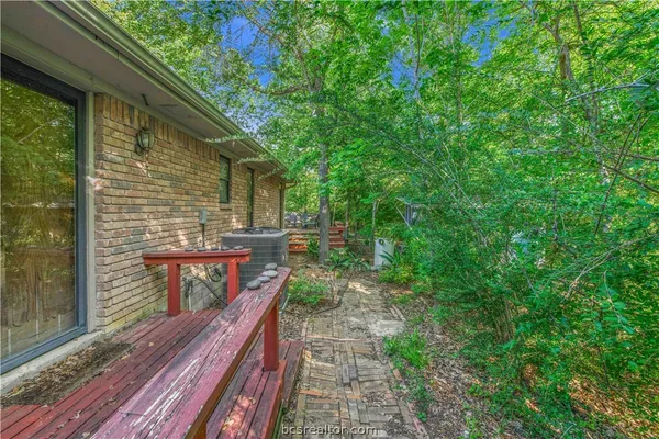 a view of a backyard with plants and wooden fence