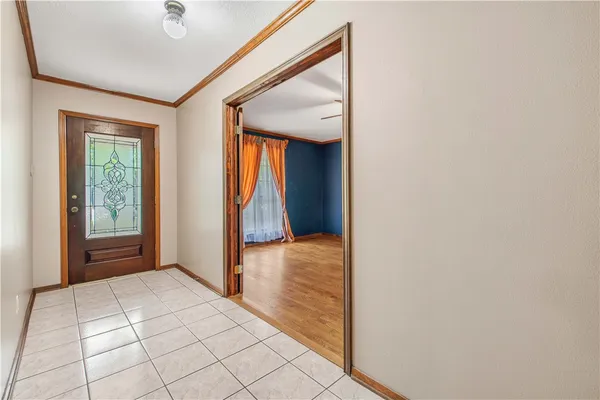 a view of an empty room with fireplace and a window