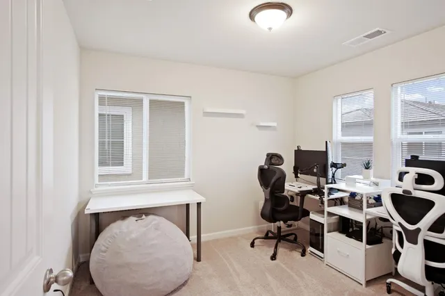 a view of workspace with a computer on the desk chairs and wooden floor