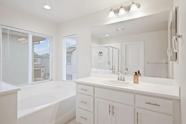 a bathroom with a tub sink and mirror