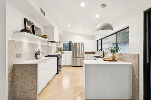 a kitchen with kitchen island a sink stainless steel appliances and cabinets