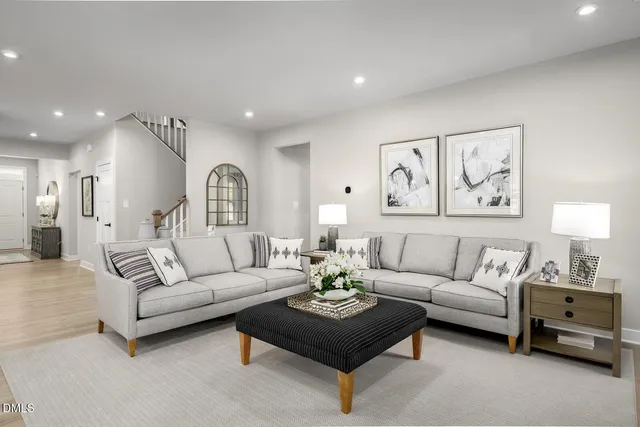 a living room with furniture kitchen view and a chandelier