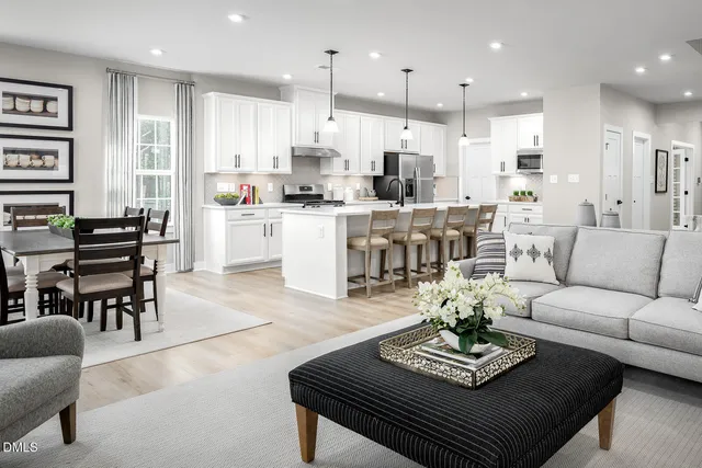 a living room with furniture kitchen view and a table