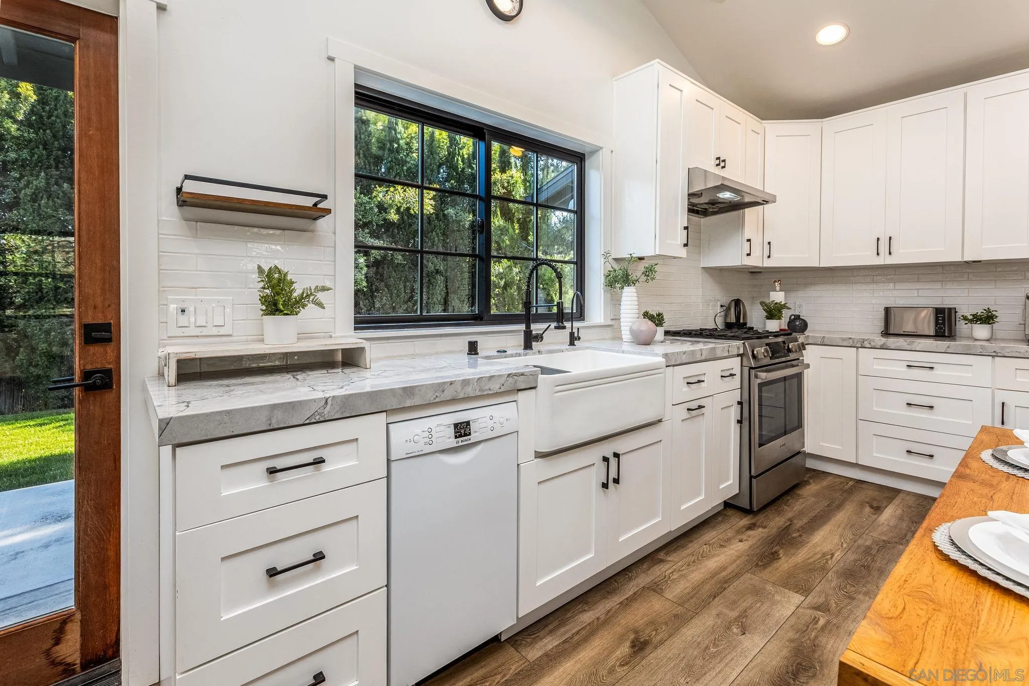 2335 Ivy Road Oceanside, CA 92054 - Photo 42 of 53 a kitchen with white cabinets a sink a window and appliances