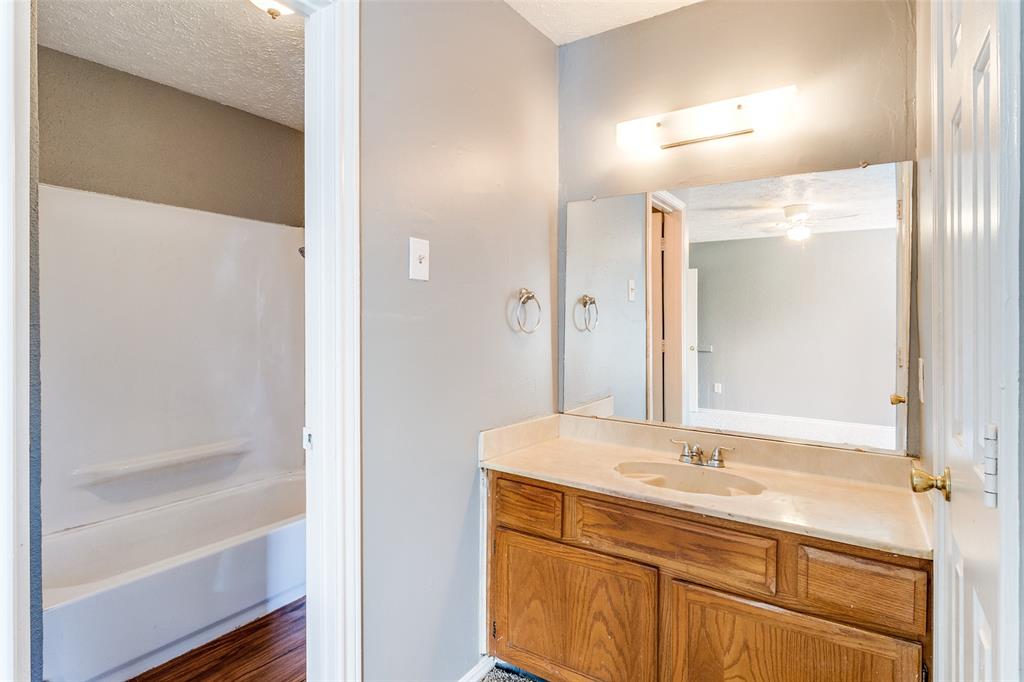 2354 Little Pocket Road, Unit B Dallas, TX 75228 - Photo 12 of 12 Bathroom featuring vanity, washtub / shower combination, dark wood finished floors, and a textured ceiling