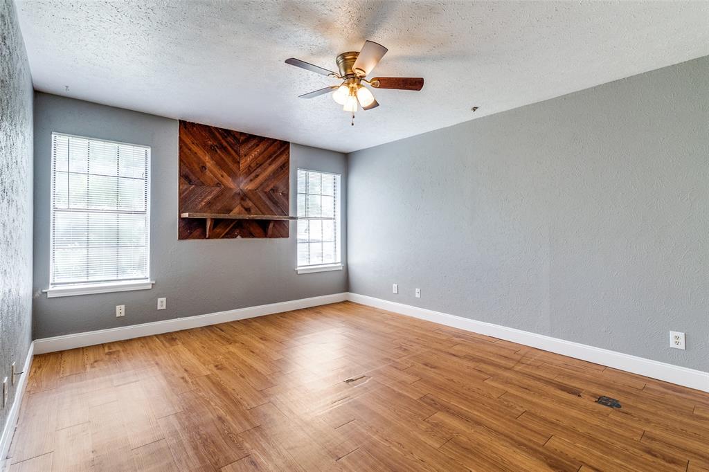 2354 Little Pocket Road, Unit B Dallas, TX 75228 - Photo 2 of 12 Empty room featuring a ceiling fan, light wood-style flooring, a textured wall, and a textured ceiling