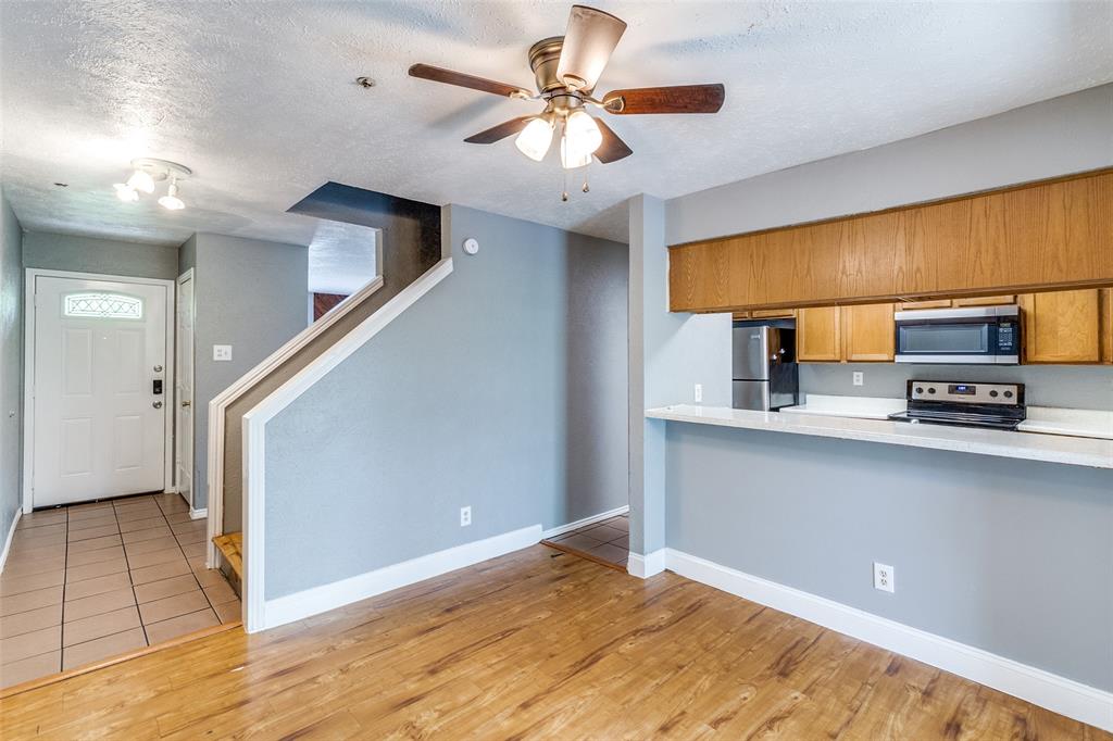 2354 Little Pocket Road, Unit B Dallas, TX 75228 - Photo 6 of 12 Kitchen with wood finish cabinets, light countertops, stainless steel appliances, a ceiling fan, and light wood finished floors