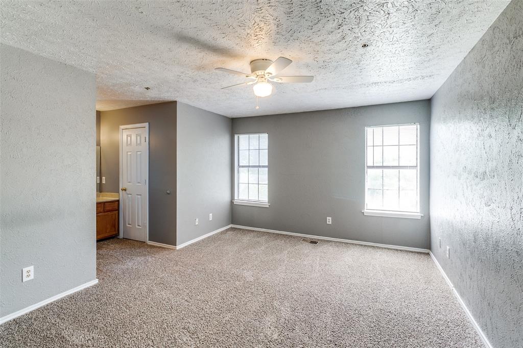 2354 Little Pocket Road, Unit B Dallas, TX 75228 - Photo 10 of 12 Empty room featuring a textured wall, ceiling fan, light colored carpet, and a textured ceiling
