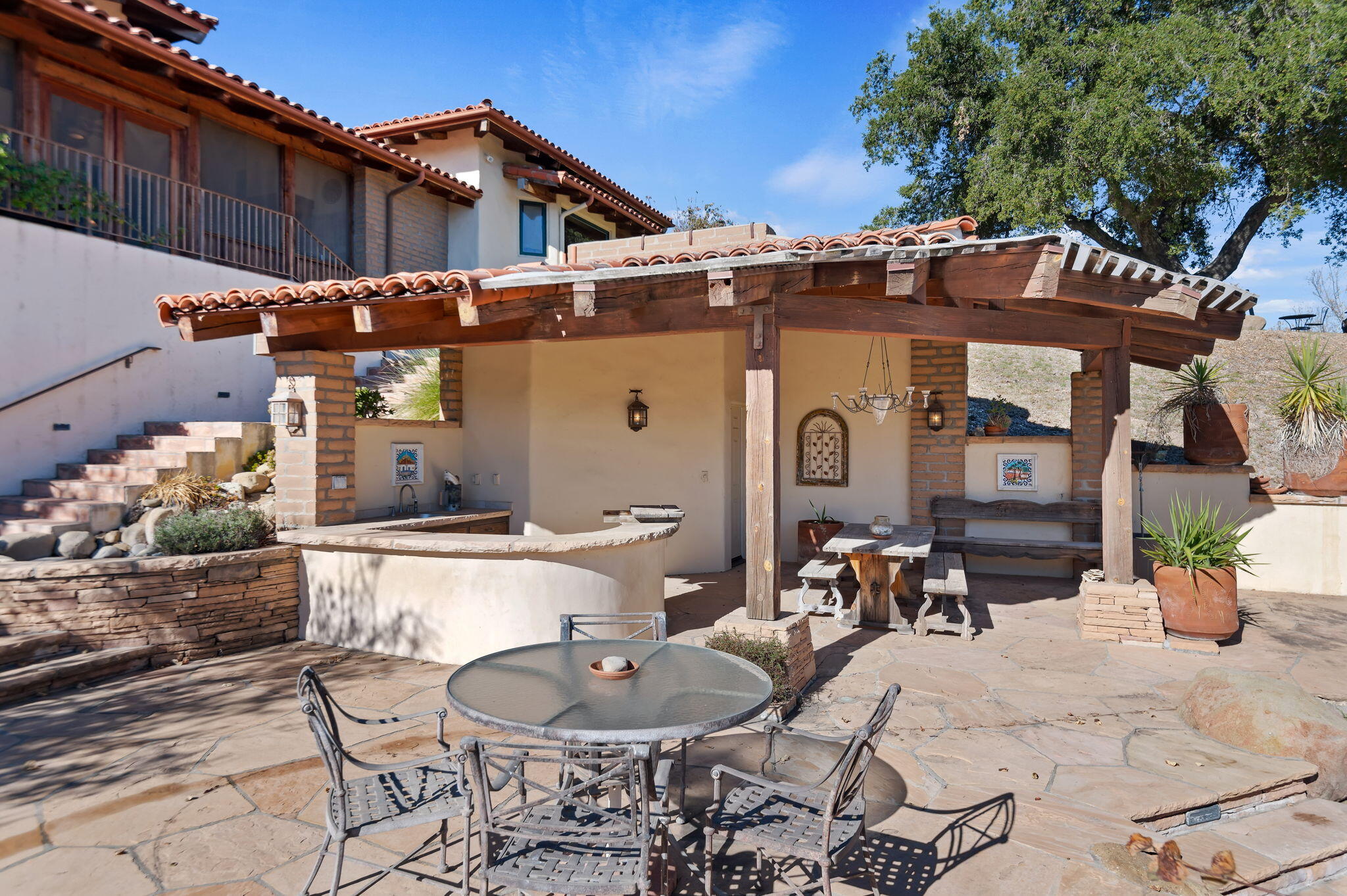 4600 Tim's Road Santa Ynez, CA 93460 - Photo 34 of 47 a view of a patio with table and chairs potted plants and a large tree