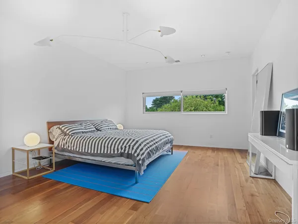 a spacious bedroom with a bed and a flat screen tv