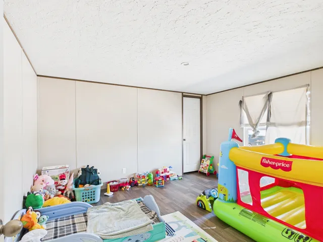 a bathroom with a granite countertop sink a toilet a mirror and shower curtain