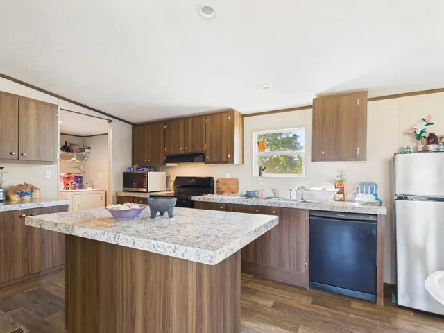 a kitchen with sink a refrigerator and wooden cabinets