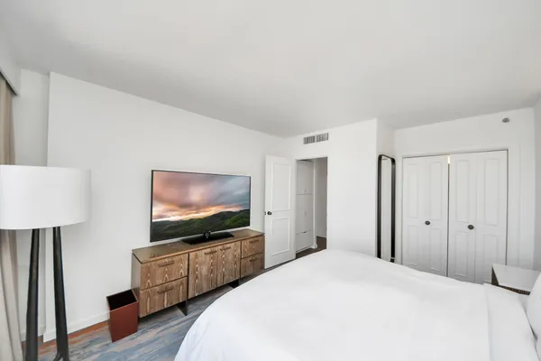 a bedroom with a bed and wooden floor