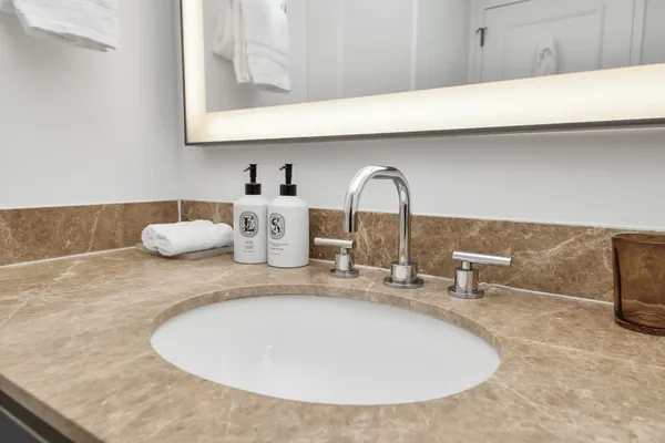 a bathroom with a tub sink and mirror