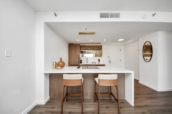 a kitchen with a dining table chairs and wooden floor