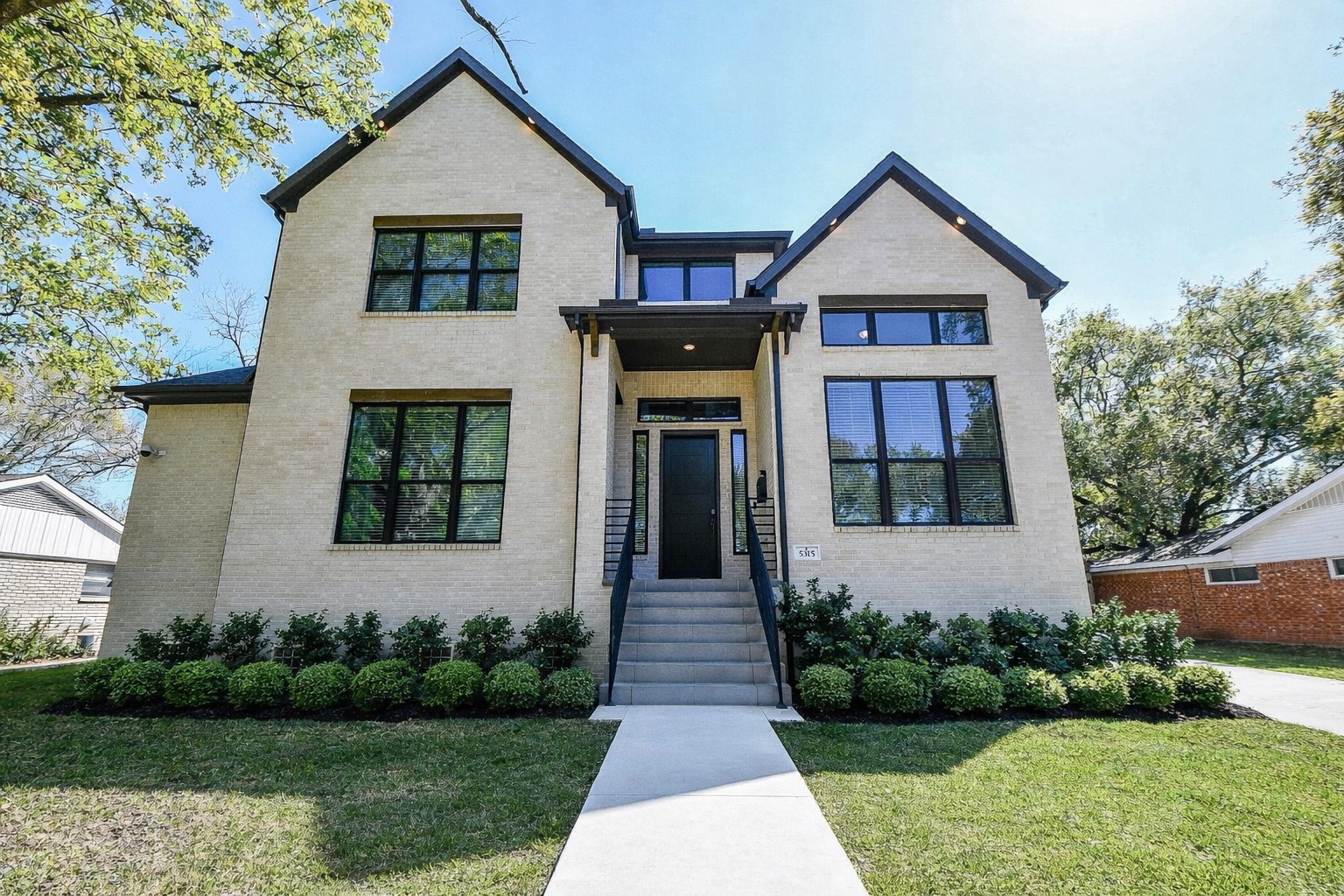Welcome home to 5315 Jason Street, an elevated modern two-story home with a light brick exterior and dark trim. It features large windows, a central entrance, and well-maintained landscaping. Luxury custom built home by Castle Rock Builders.