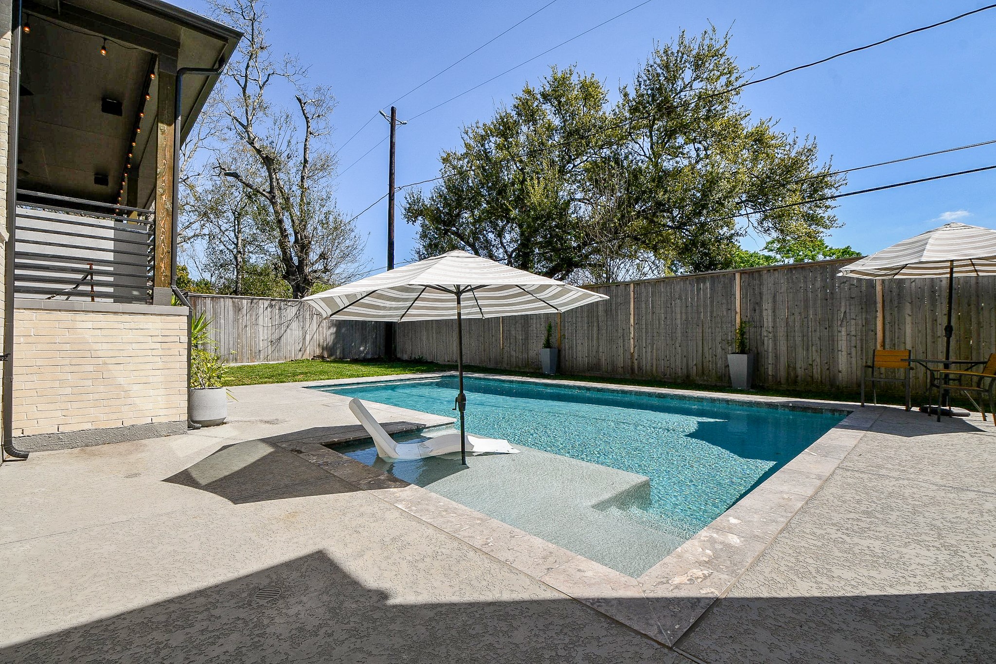 5315 Jason Street Houston, TX 77096 - Photo 14 of 39 A fresh perspective of the sparkling pool showcases sun and shade alongside an in-water chair—perfect for laid-back lounging.