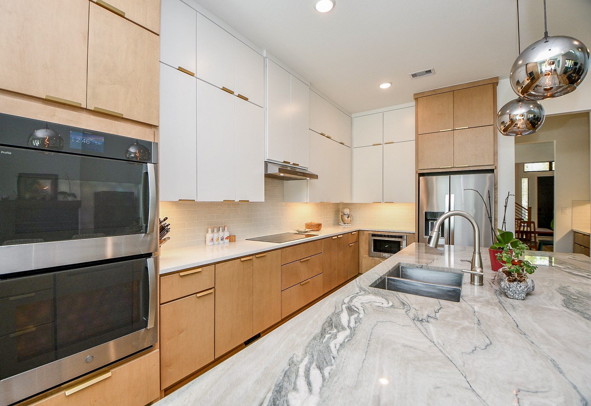 5315 Jason Street Houston, TX 77096 - Photo 7 of 39 Rich caramel cabinetry is perfectly balanced by extensive white upper storage, delivering a clean, streamlined aesthetic with warmth and contrast.