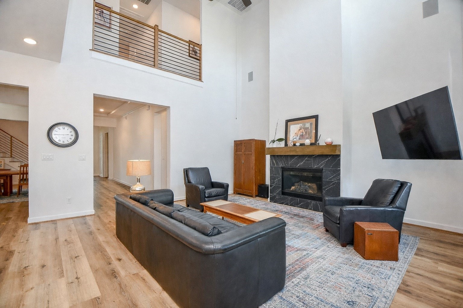 5315 Jason Street Houston, TX 77096 - Photo 10 of 39 Designed for both comfort and style, this living room offers high ceilings, an open layout, and a sleek fireplace as a focal point. Warm wood flooring and relaxed seating create an inviting space to gather and unwind.