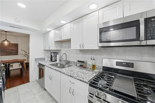 a kitchen with stainless steel appliances granite countertop a stove microwave and cabinets