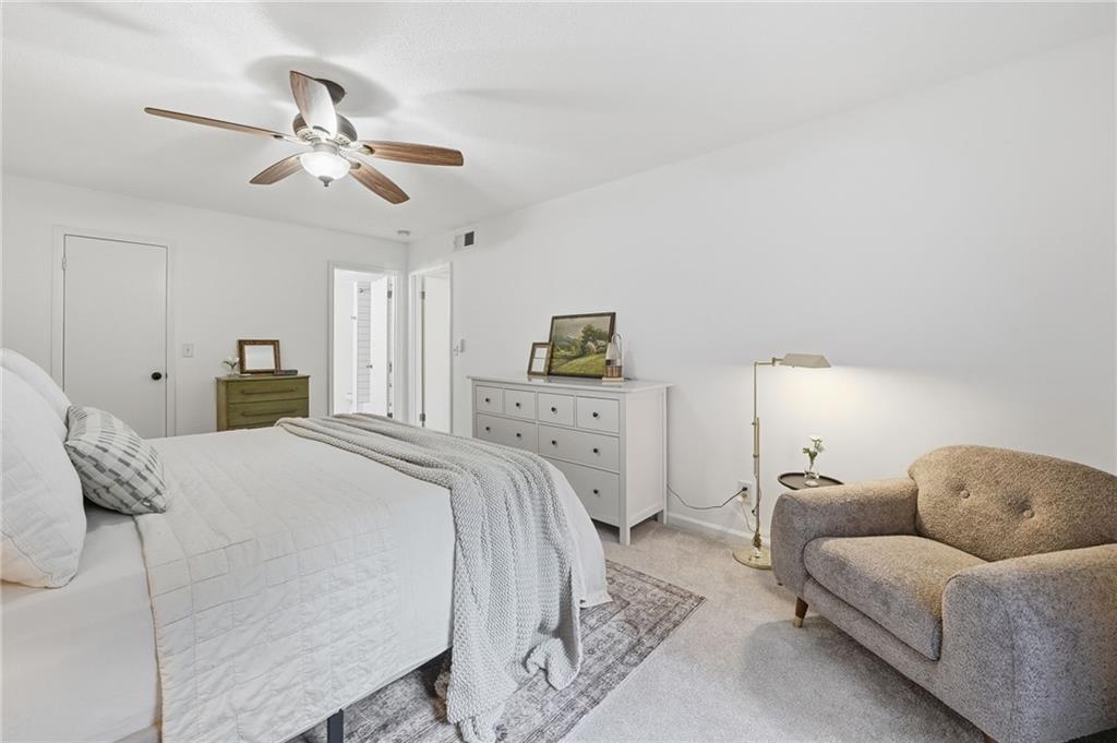6851 Roswell Road, Unit H29 Atlanta, GA 30328 - Photo 18 of 50 a spacious bedroom with a bed and ceiling fan