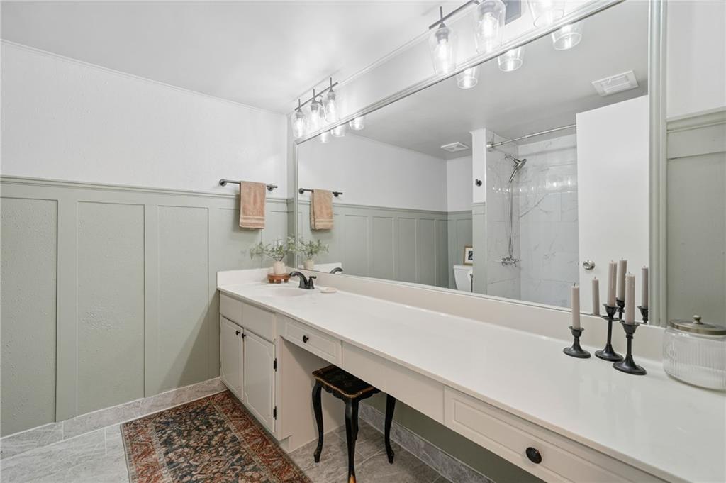 6851 Roswell Road, Unit H29 Atlanta, GA 30328 - Photo 24 of 50 a bathroom with a sink a mirror and a shower